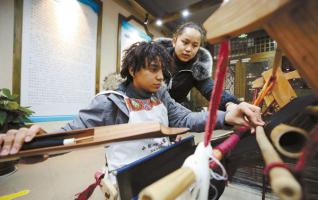 Overseas Volunteers Try Tujia Brocade in Zhangjiajie